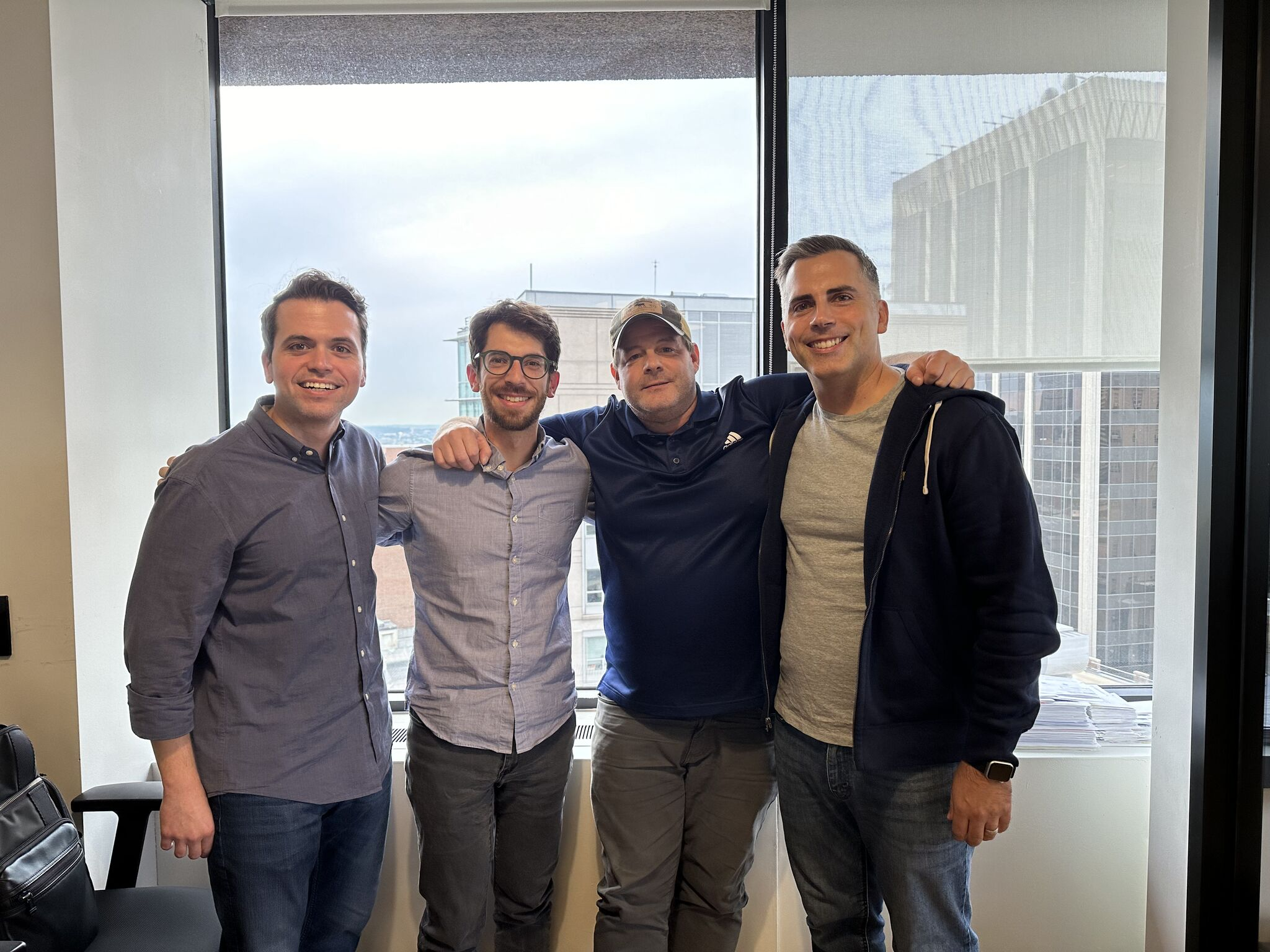 Team members at the Survey office posing together in front of a window overlooking the city.