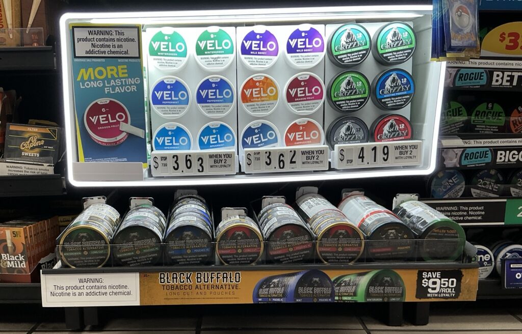 Convenience store shelf featuring smokeless tobacco products with branded point-of-sale materials installed to improve product visibility and in-store execution.